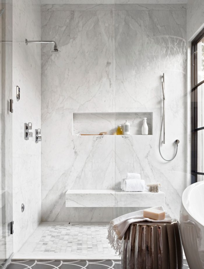 A luxurious bathroom with marble flooring and white walls.